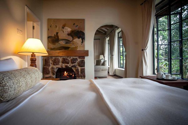 Cozy fireside bed in the Clouds cottages Clouds Mountain Gorilla Lodge Bwindi Uganda Wetu